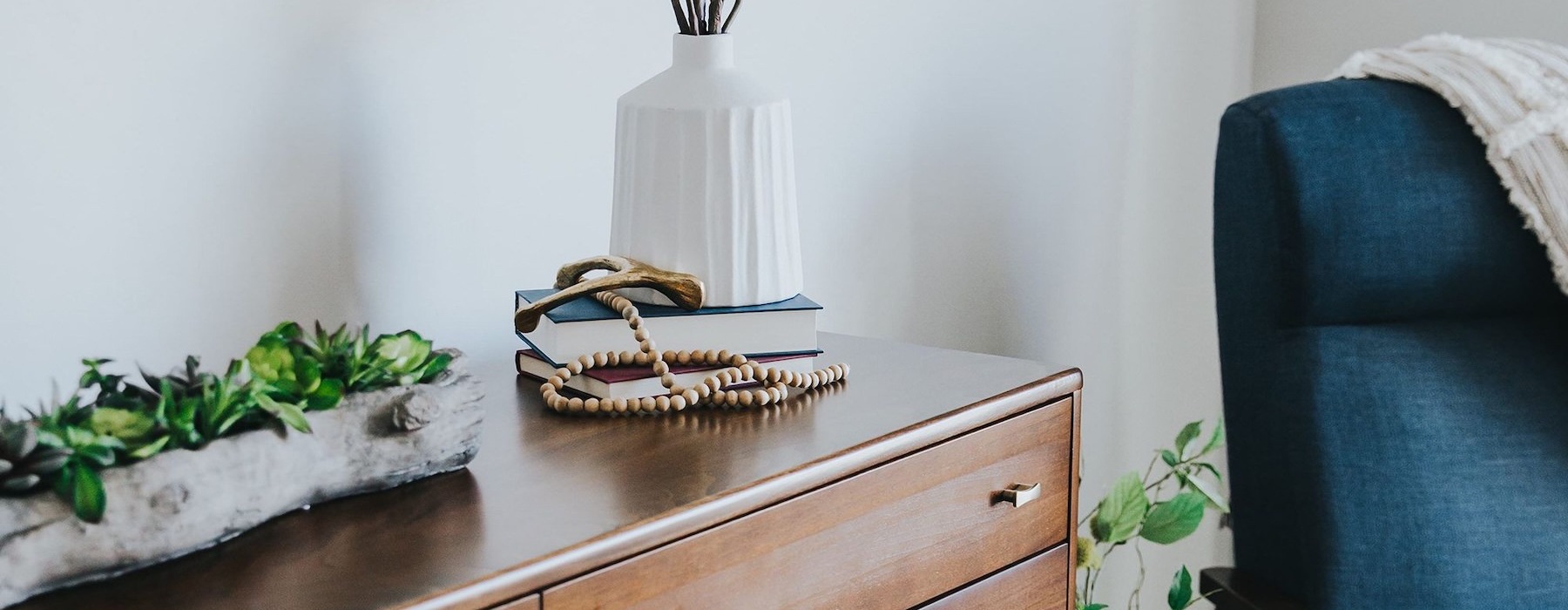 a room with a dresser and a blue chair